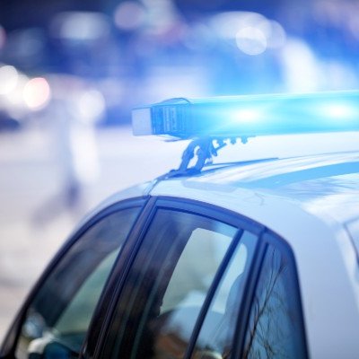 Police car with blue lights in urban setting.